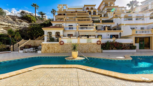 A large, multi-story hotel with a swimming pool, outdoor seating, and a landscaped garden. - Sea View Apartment Windsor Park (Adeje)