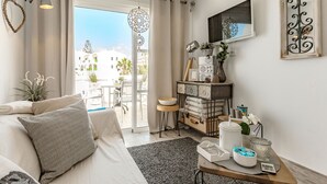 A modern living room with a sofa, a coffee table, and a view of the outside. - Sea View Apartment Windsor Park (Adeje)