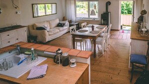 A cozy kitchen with a wooden countertop, a dining area with a table and chairs, and a sofa in the background. - Old house to feel good (Usingen)