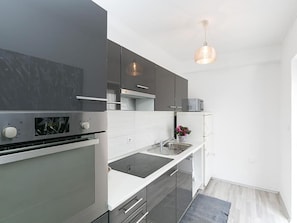 A modern kitchen with a built-in oven, a sink, and a countertop.