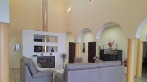A spacious living area with a fireplace, two grey sofas, and a white entertainment unit. - Exclusive CHALET near SEVILLA Andalusia with pool for 14 people  (Lora del Río)