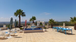 A rooftop terrace with a pool, lounge chairs, umbrellas, and a view of the landscape. - Exclusive CHALET near SEVILLA Andalusia with pool for 14 people  (Lora del Río)