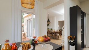 Una encimera de cocina con un frutero, una botella de zumo de naranja y un plato de comida.