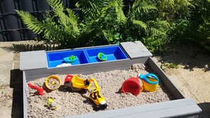 A sandbox with toys and a blue water table. - Large, cozy vacation home with garden between St. Peter-Ording & Büsum (Wesselburen)
