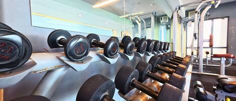 Ein Fitnessstudio mit Reihen von Kurzhanteln und Trainingsgeräten.