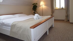 Ein Schlafzimmer mit einem hölzernen Bett, einer Nachttischlampe und einem Fenster mit Vorhängen.