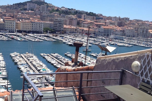 Terrasse extérieure équipée d'une table et barbecue electrique