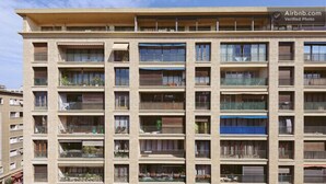 A multi-story apartment building with balconies, a sign indicating Airbnb availability, and a clear sky. - Vieux Port to Notre Dame de la Garde Triplex 70 m2 terrace (Marseille)