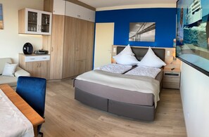 Une chambre à coucher comprenant un lit, des tables de chevet, un bureau et une armoire.