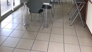 A dining area with a table and chairs, a microwave, a cabinet, and a sliding glass door leading to an outdoor area.