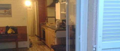 A compact living space with a kitchenette, a bed, and a dining area.