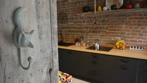 Una cocina con pared de ladrillo, encimera de madera y un lavamanos.