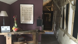 Un interior rústico con una mesa de madera, un cuadro en la pared y un letrero que dice 'LA BENARDIERE'.