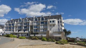 A multi-story residential building with balconies, large windows, and a stone facade. - Seaview ! Bright veranda apartment at the foot of the beach  (Clohars-Carnoët)