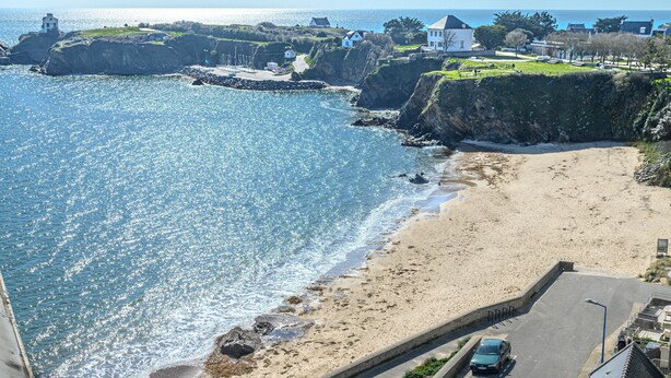 A coastal town with a sandy beach, a road, and buildings. - Seaview ! Bright veranda apartment at the foot of the beach  (Clohars-Carnoët)