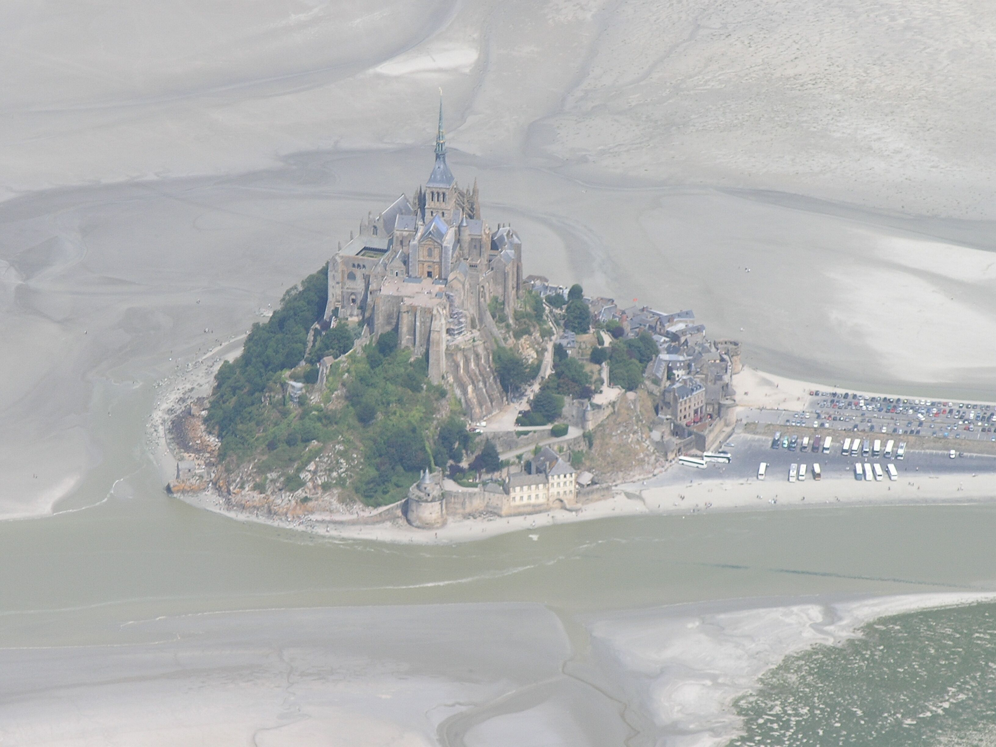 Eine Luftaufnahme eines Schlosses auf einer Felseninsel, umgeben von Wasser.
