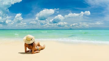 Una playa cerca, sillas reclinables de playa, toallas de playa