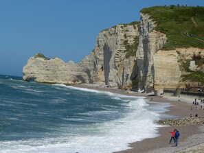 A coastal landscape with cliffs, a beach, and the ocean.