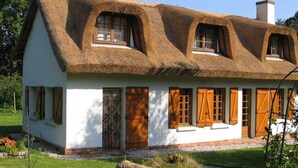 A traditional house with a thatched roof, white walls, and wooden shutters. - La Flore Marine, Lovely cottage 330 m from the sea and 6 km from Étretat! (Saint-Jouin-Bruneval)