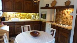 A kitchen with wooden cabinets, a gas stove, a microwave, and a coffee maker. - La Flore Marine, Lovely cottage 330 m from the sea and 6 km from Étretat! (Saint-Jouin-Bruneval)