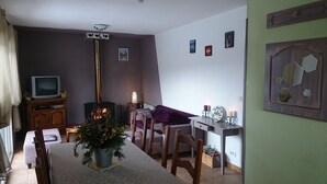 Un salon confortable avec une cheminée, une table à manger et un téléviseur.