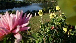 Un lac où l’on peut faire du bateau, entouré de collines et bordé de fleurs en pleine floraison.