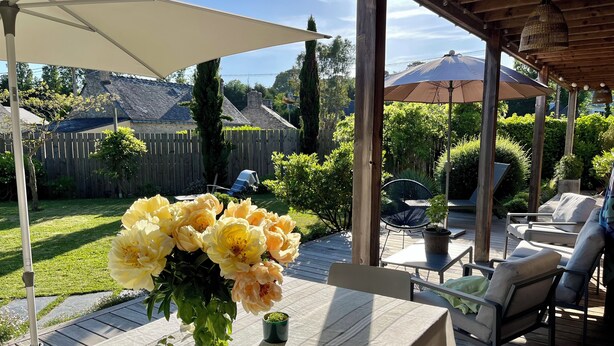 A covered patio area with a table, chairs, and potted plants. - Great longère ideally located (Arradon)