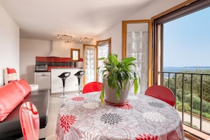Eine moderne Wohnung mit Balkon, Essbereich und Küche.
