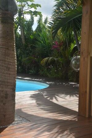 A wooden deck with a pool, surrounded by tropical plants and a glass sphere. - Charming "La Laurma" chalet, private and ethical, with private swimming pool (Saint-André)