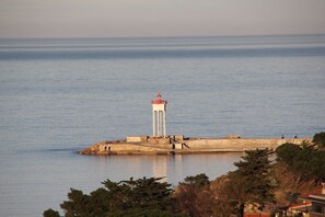 Un far a una petita illa, amb aigües tranquil·les al fons.