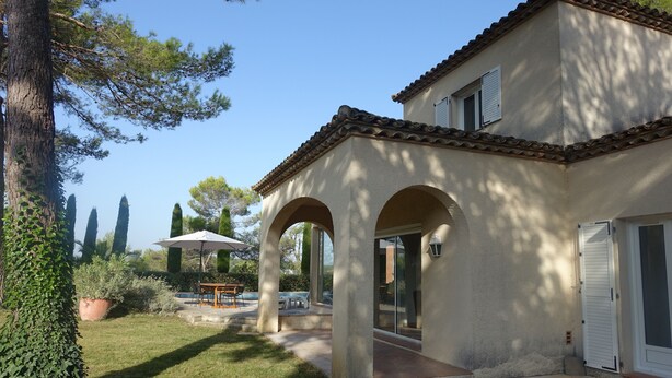 A house with a patio, a swimming pool, and a garden.