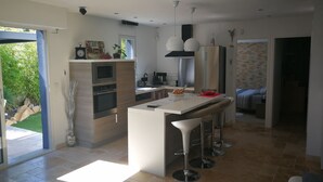 A modern kitchen with a central island, built-in oven, and stainless steel appliances.