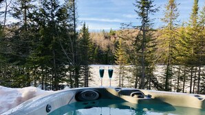 A hot tub with two blue loungers, surrounded by snow and trees. - LAKEFRONT (private quay)-SPA-BILLARD-PING PONG-WORKING TABLE (Mille-Isles)