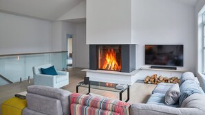 A modern living room with a fireplace, a sofa, a coffee table, and a TV. - LAKEFRONT (private quay)-SPA-BILLARD-PING PONG-WORKING TABLE (Mille-Isles)
