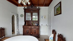 Un dormitorio con una cama grande, cómoda de madera y un candelabro.