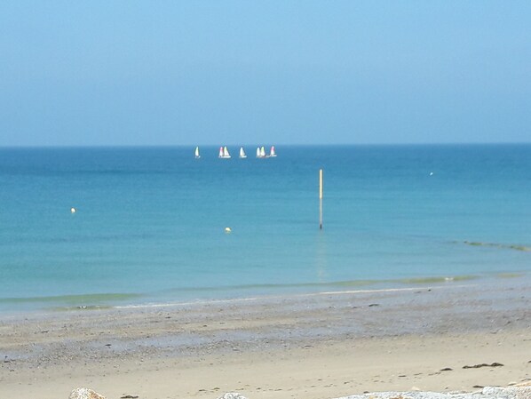 Enjoy a serene beach experience with a gentle slope leading to the calm waters.