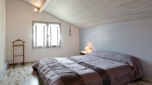 A bedroom with a large bed, a wooden ladder, a window, and a nightstand with a lamp. - Spacious 410m² 3-star cottage: private heated pool, spa, canoes and paddl (Trentels)