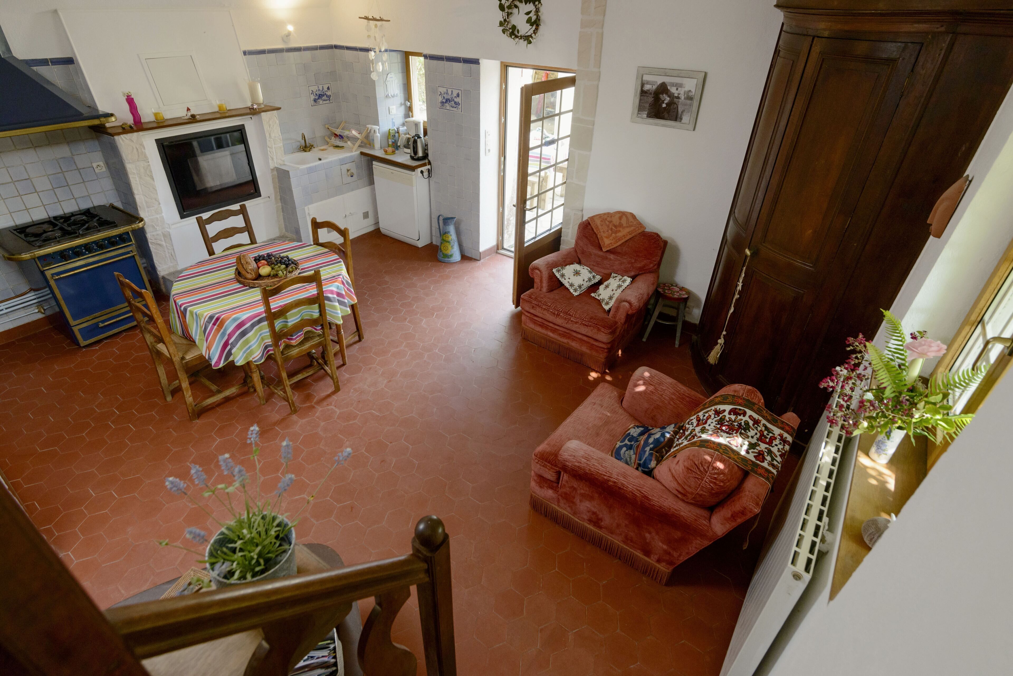 A spacious living area with a dining table, a sofa, and a kitchen in the background.