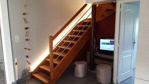 Eine Treppe mit Holzgeländern und einem an der Wand befestigten Fernseher.
