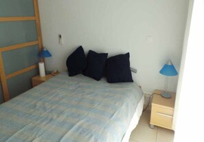 Ein Schlafzimmer mit einem Bett, zwei Nachttischen und zwei Lampen.