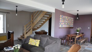 Un salon avec un canapé gris, une table basse en bois et un escalier.