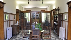 Une salle à manger avec une table et des chaises en bois, entourée d’armoires et d’étagères en bois.