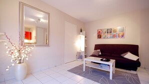 Ein modernes Wohnzimmer mit einem weißen Sofa, einem Couchtisch und einem großen Spiegel.