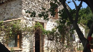 Un edificio in pietra dal aspetto rustico, con una porta e delle finestre in legno.
