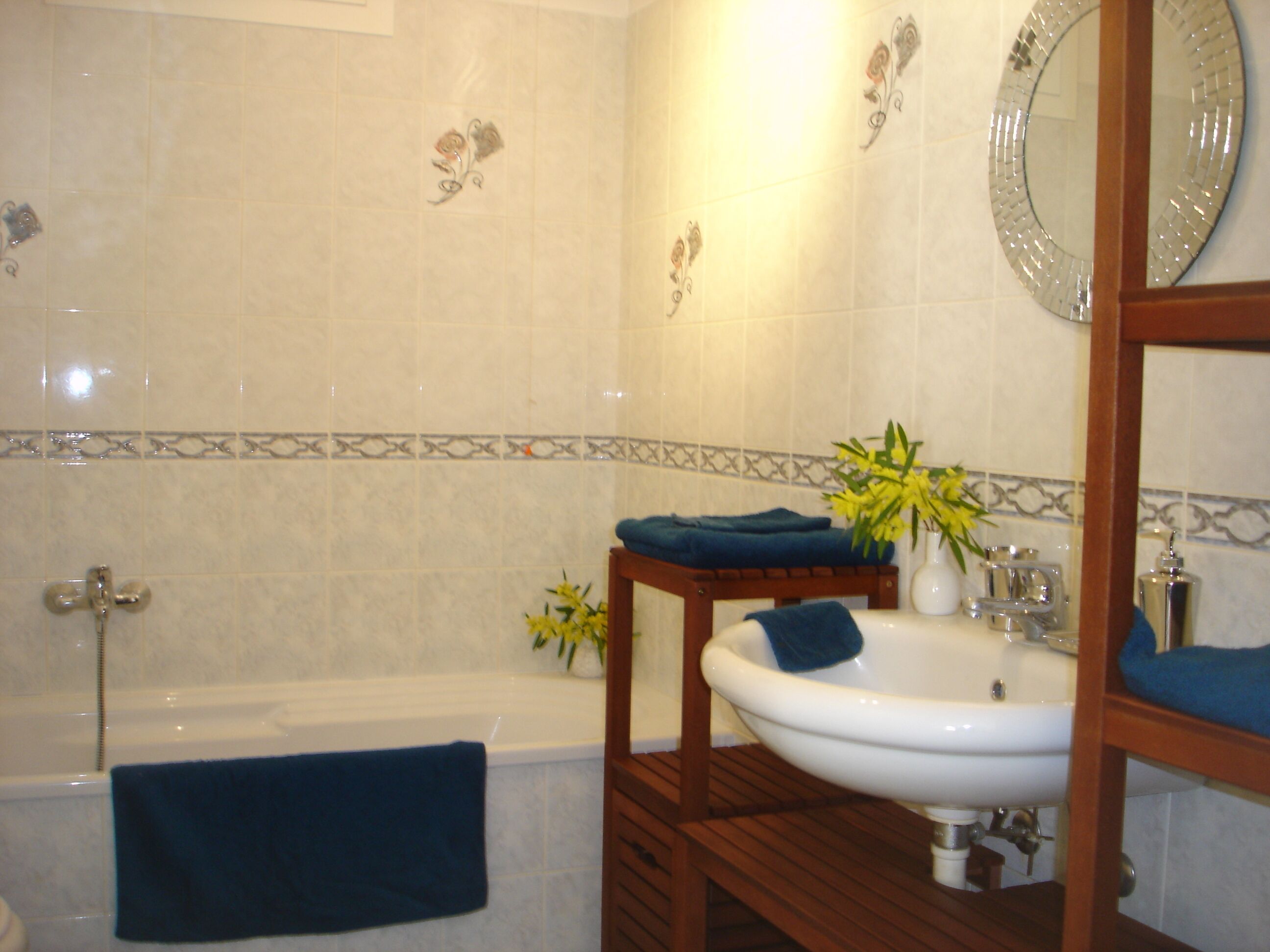 Een badkamer met een bad, een wastafel en een spiegel.