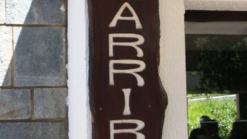 Un letrero de madera con el nombre 'LARRIBAU' en la fachada de un edificio.