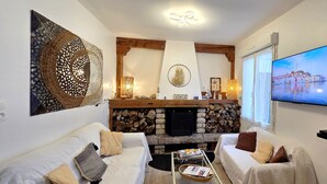 A cozy living room with a fireplace, a television, and a comfortable seating area.