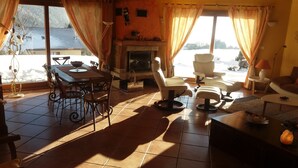 Una sala de estar acogedora con chimenea, un comedor con mesa y sillas, y un sofá.