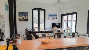 Een moderne woonkamer met een bank, eettafel en een keukenhoek.