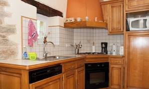A kitchen with wooden cabinets, a dishwasher, an oven, and a microwave.